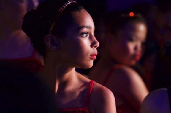 Dancers backstage watch the show as they await their turn to perform.
